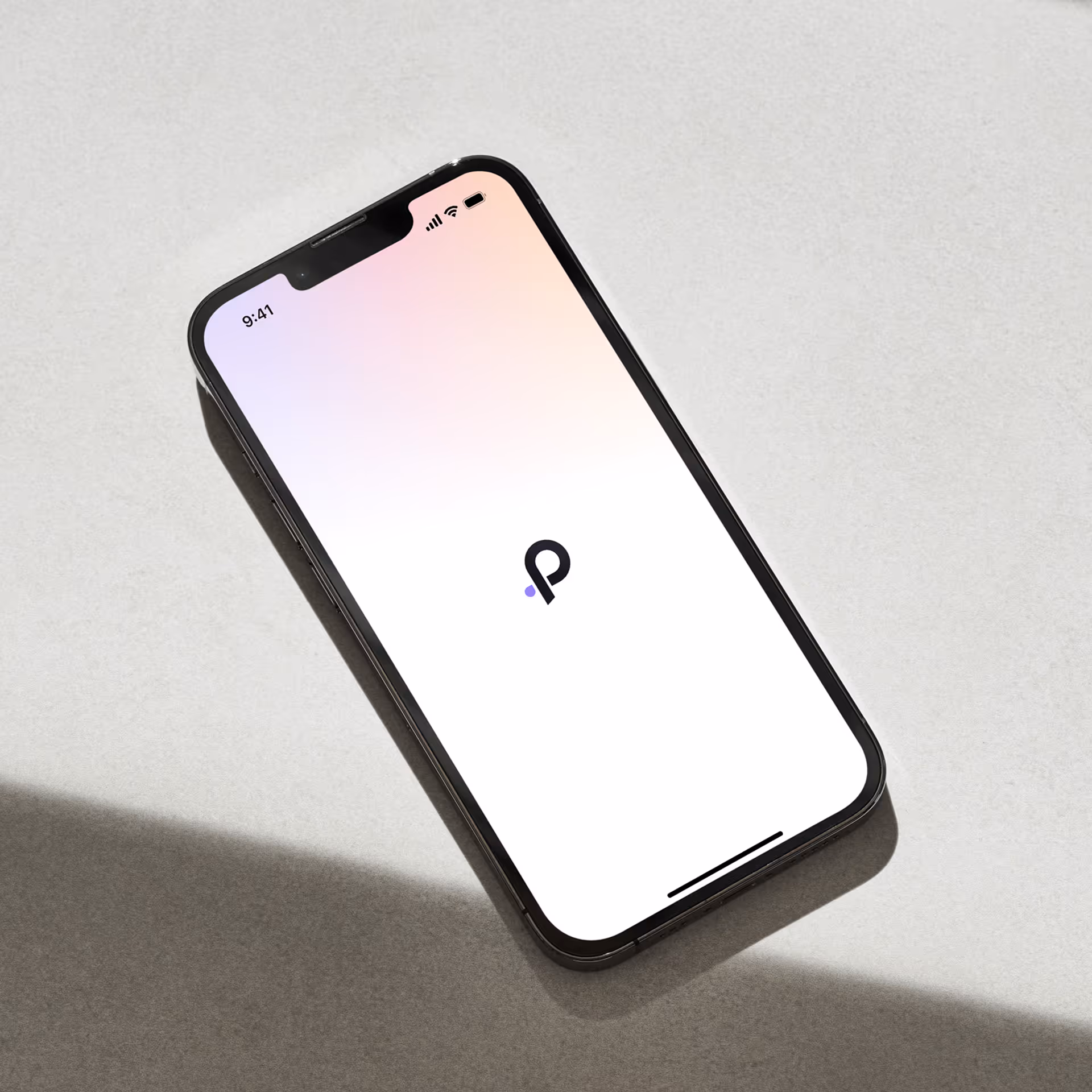 Smartphone lying on a light surface displaying a minimalist app loading screen with a black and purple logo in the center.