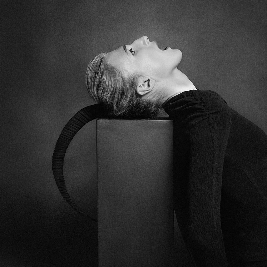 Ritratto in bianco e nero di Tony Hassler, posa scultorea su cubo