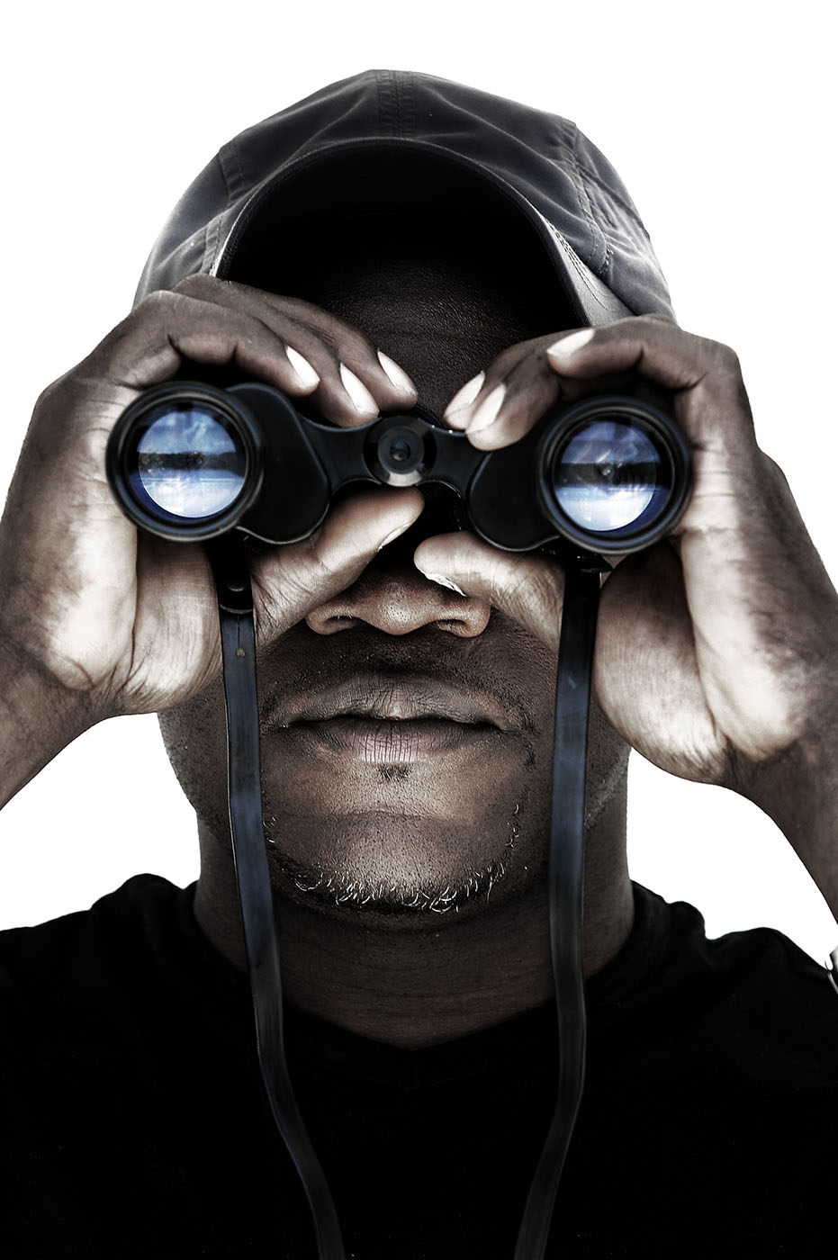 Tony Hassler looks through binoculars, reflecting snowy landscape in lenses