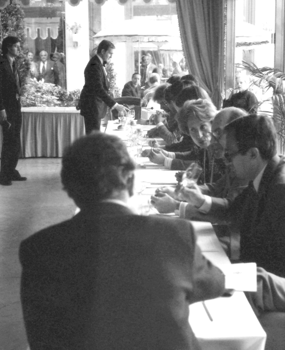Black and white photograph of the 1976 Judgment of Paris wine tasting, showing the judgest table and judges evaluating wines.