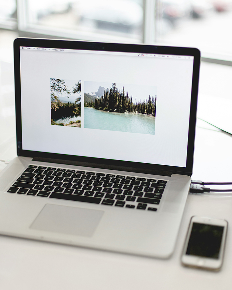 A laptop  and smartphone on a desk side by side | Kelly Agency Images