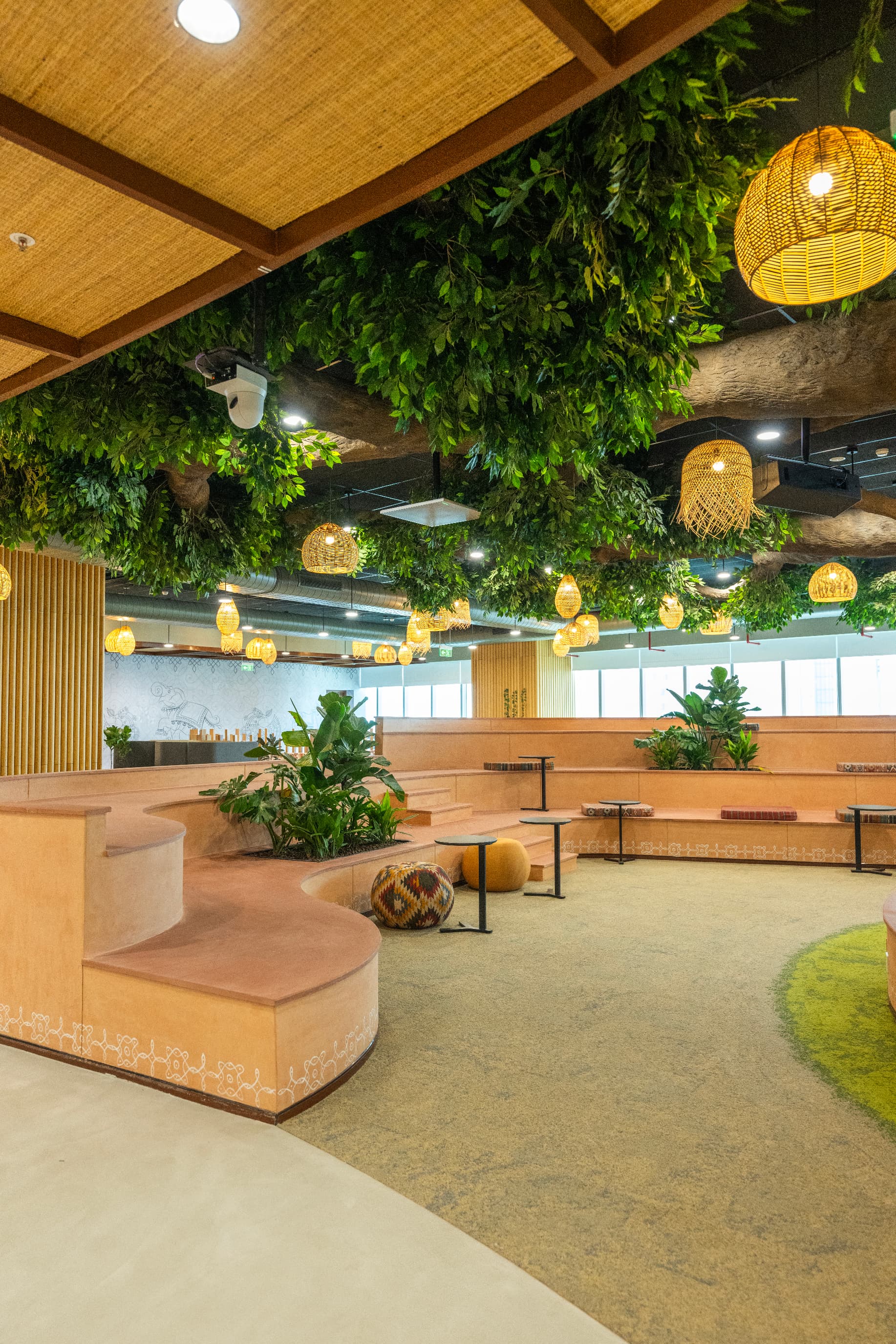 Ceilings are woven from bamboo and rattan mats sourced from Nagaland, with pendant lights made by the same artisans. Seating steps down in dholiya stone tiers, a reference to the medieval stepwells found across India.