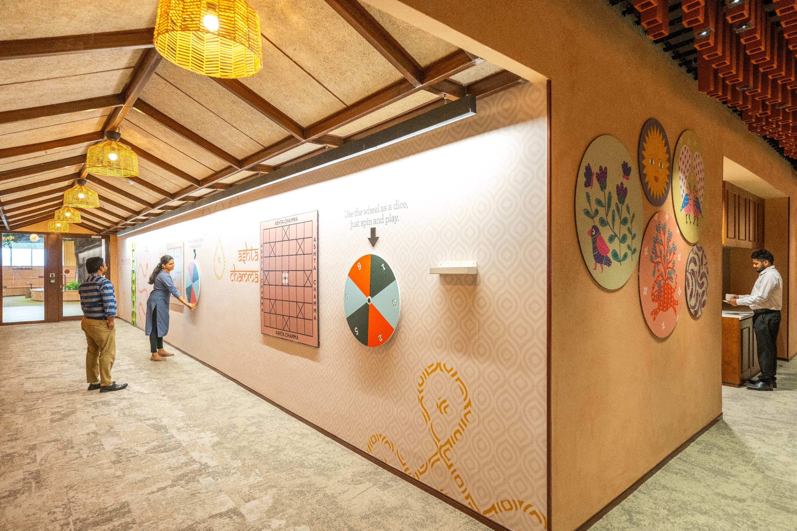 Corridors connecting the social areas carry wall-mounted traditional games, including ashta chamma and carrom, offering pause points and opportunities for informal interaction.
