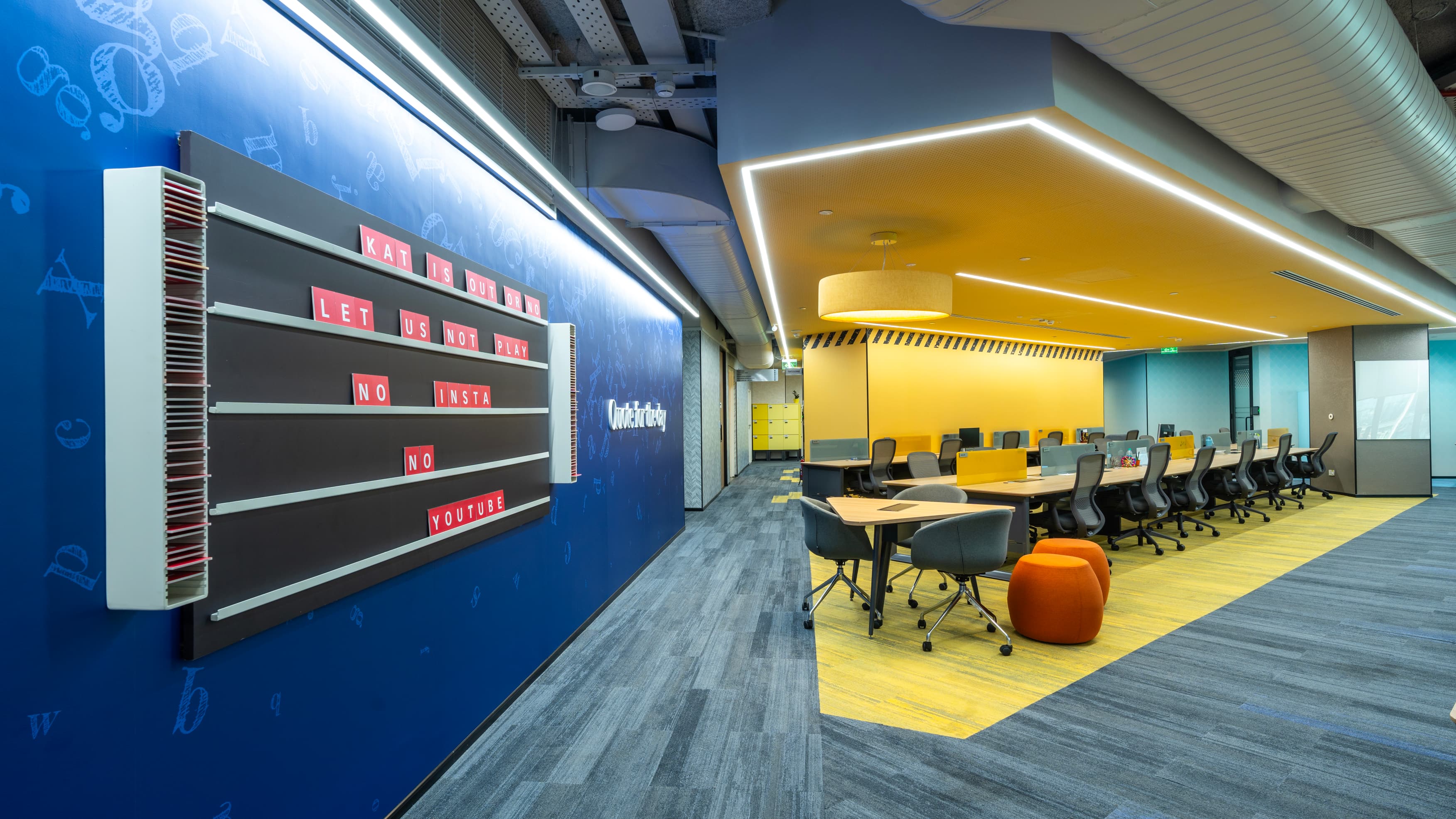 Colour-blocked carpet and ceiling rafts identify each neighbourhood core, giving teams a legible home base on floor plates that run the full width of the tower.