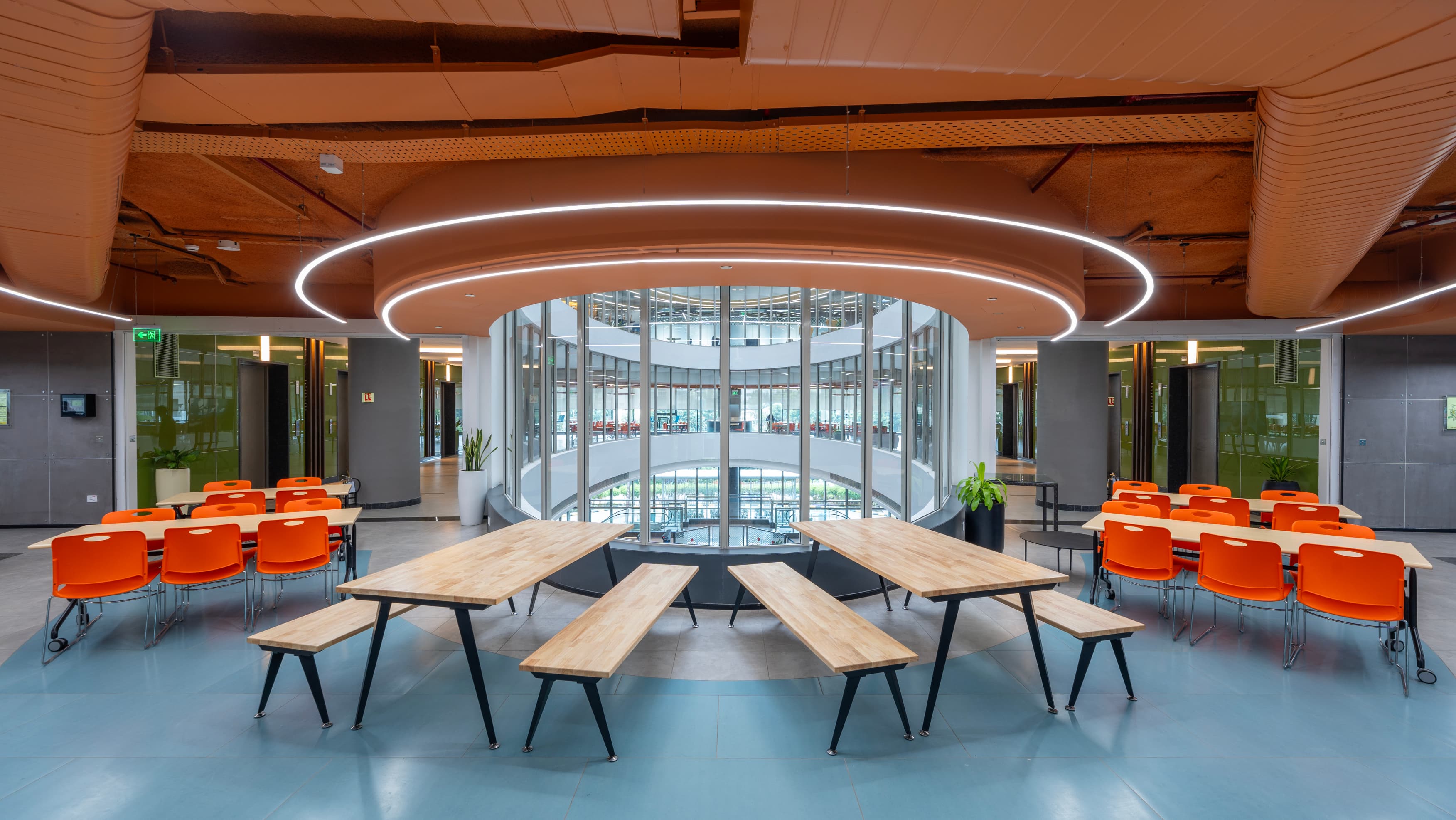 The 942-seat cafeteria doubles as an all-hands venue. Lightweight furniture and retractable AV switch it from lunch service to company briefing without additional facilities support.