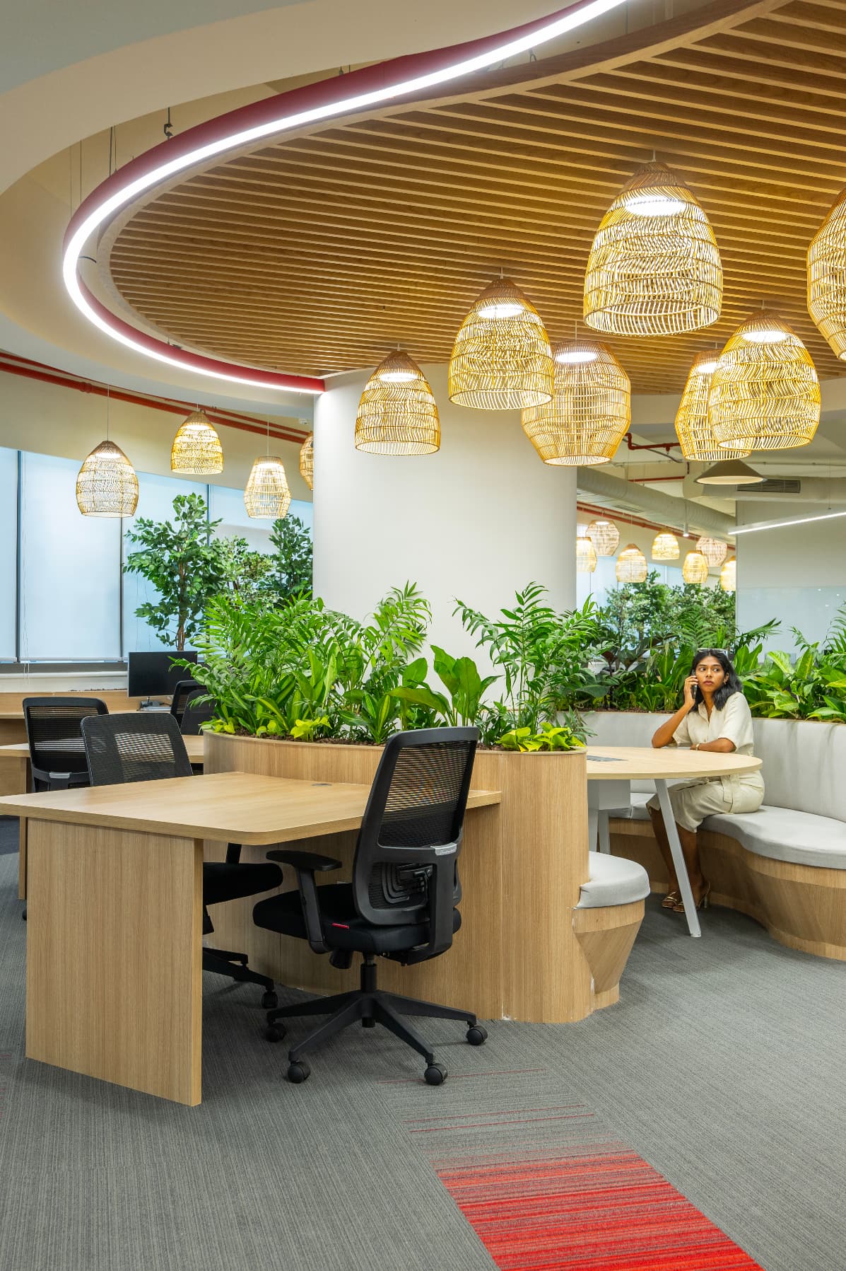 Bamboo lights punctuate the key zones with handcrafted softness, their organic forms bringing tactility to overhead planes. Curved planters and banquette seating break the floor into intimate pockets.