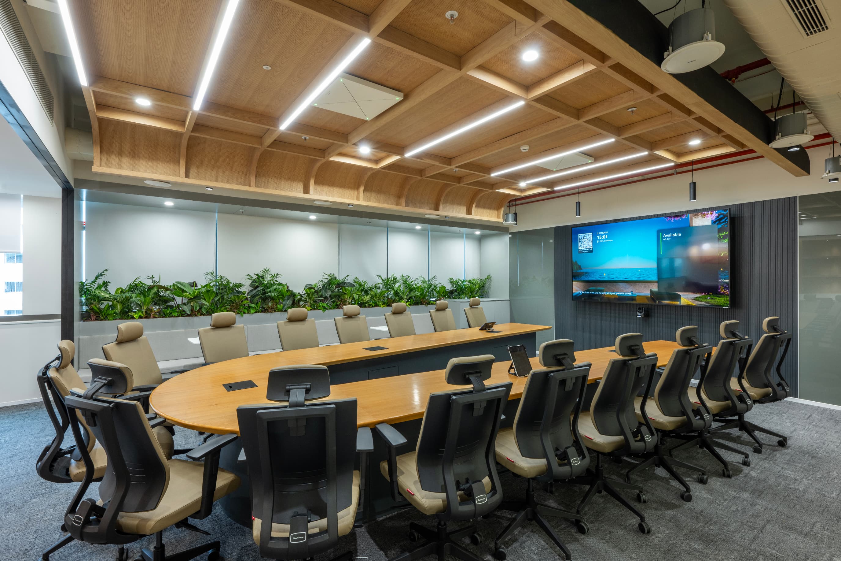 The boardroom sits at one end beneath a perforated laminated wooden ceiling whose meticulous detailing embodies the Japanese principle of craft serving purpose.