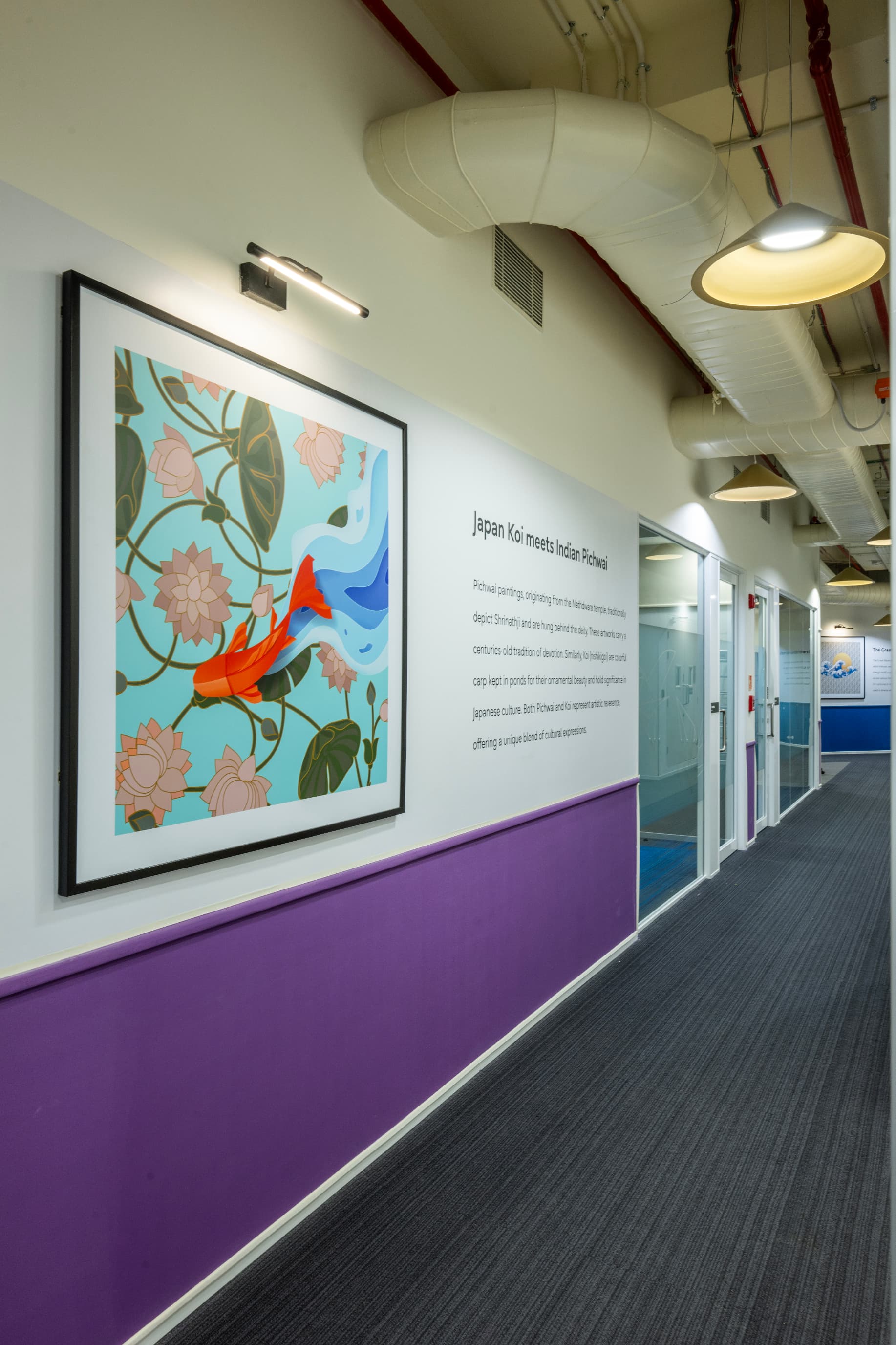 Koi swim alongside Pichwai iconography. Each pairing in the art programme is captioned on the wall, turning the corridor into a running commentary on where the two traditions meet.