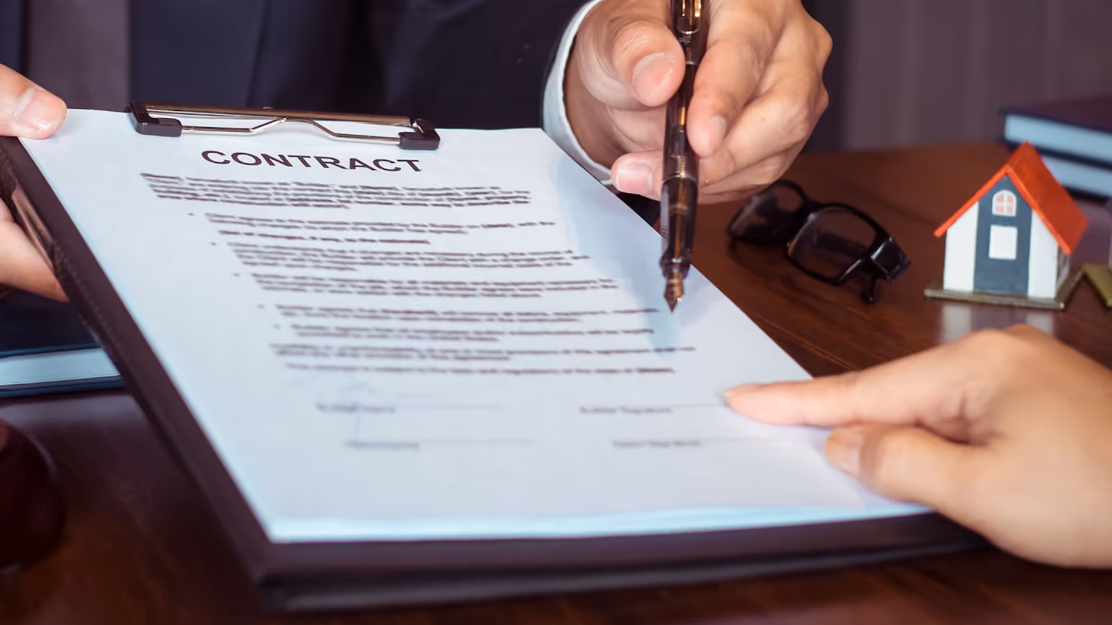 A person signing a contractAI-generated content may be incorrect.