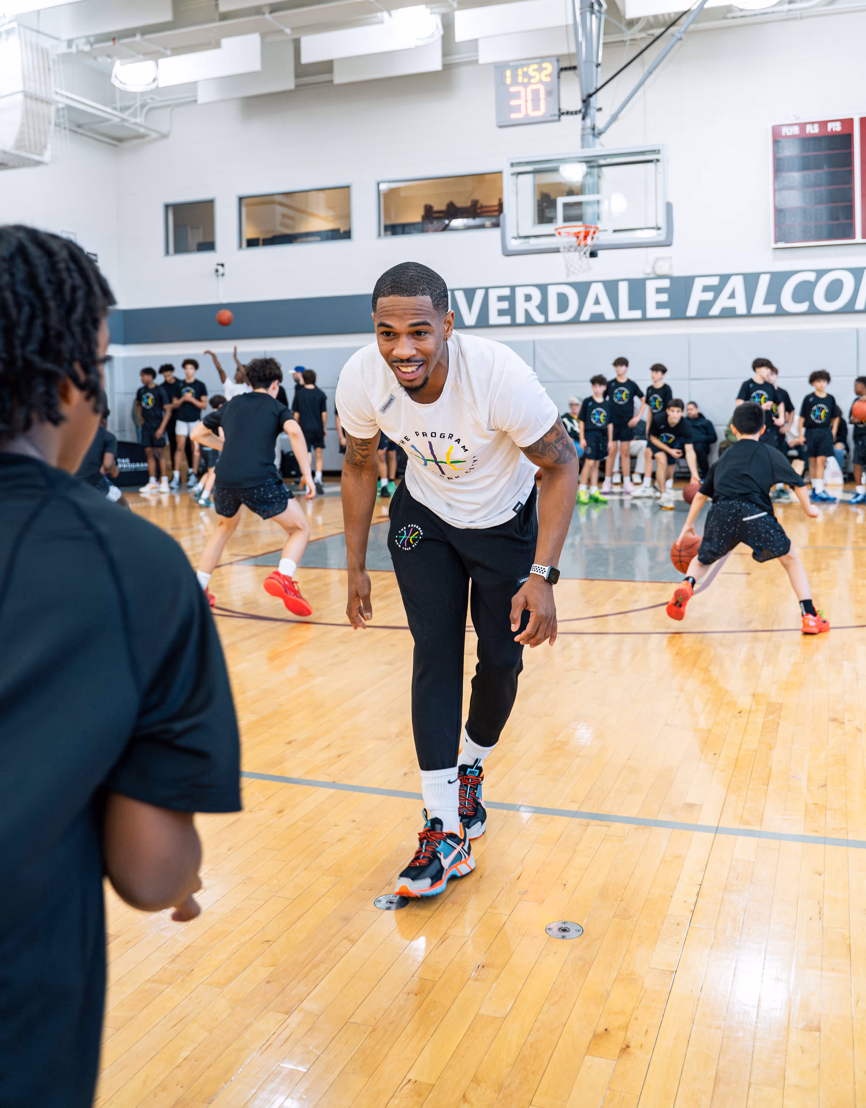 Basketball instructor from The Program NYC teaching a group of middle and high school students at the Riverdale courts