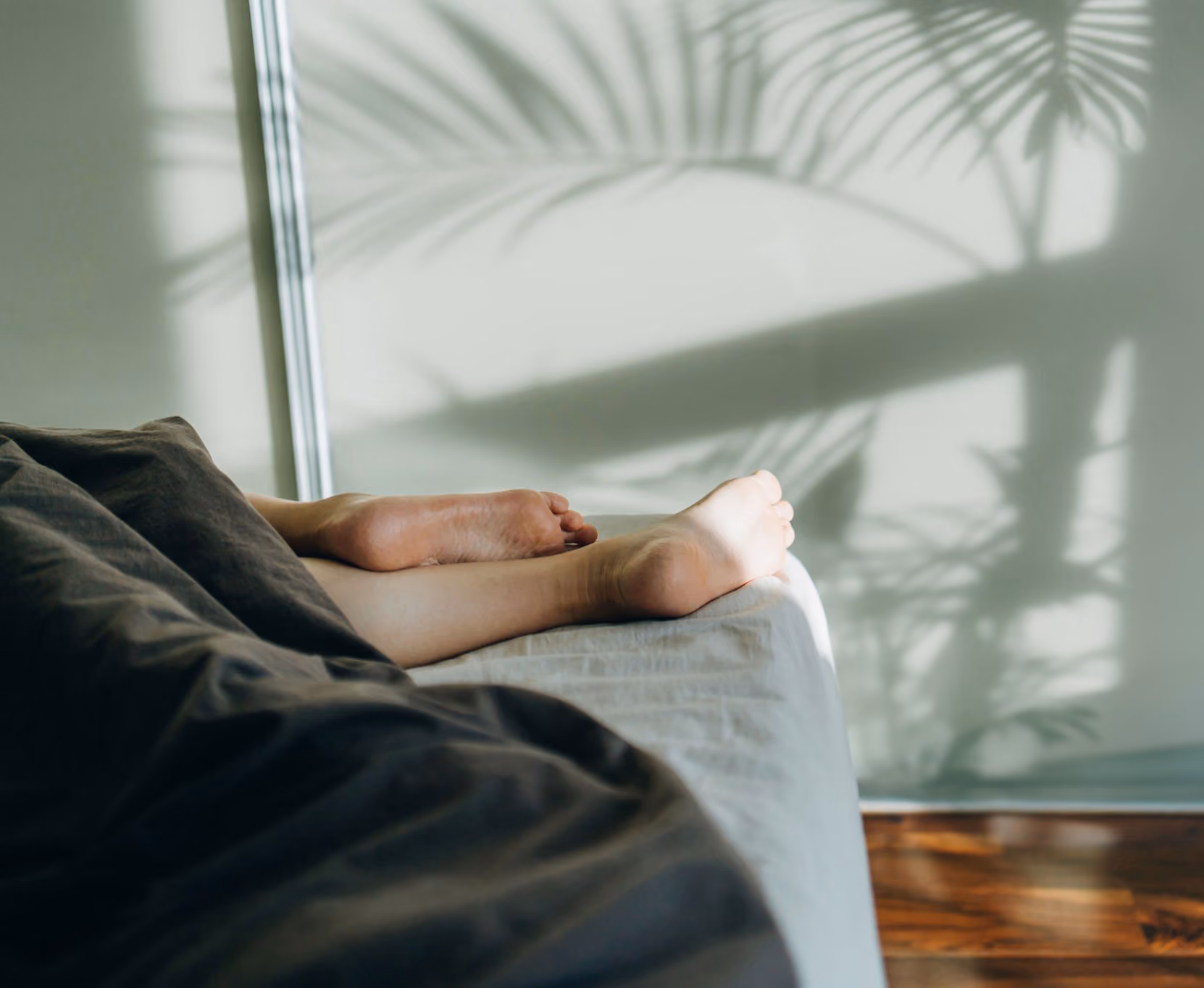 Morning photo of woman's feet on bed.