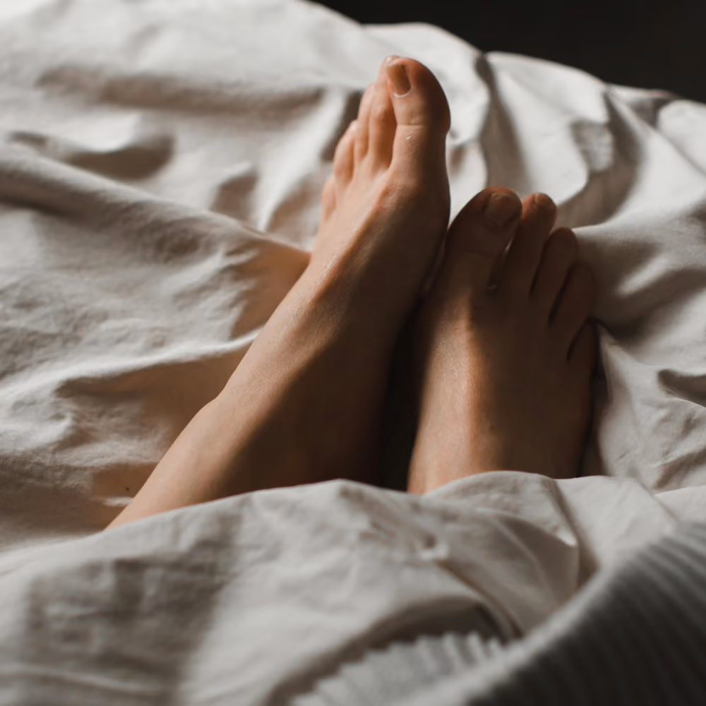 Morning photo of woman's feet on bed.