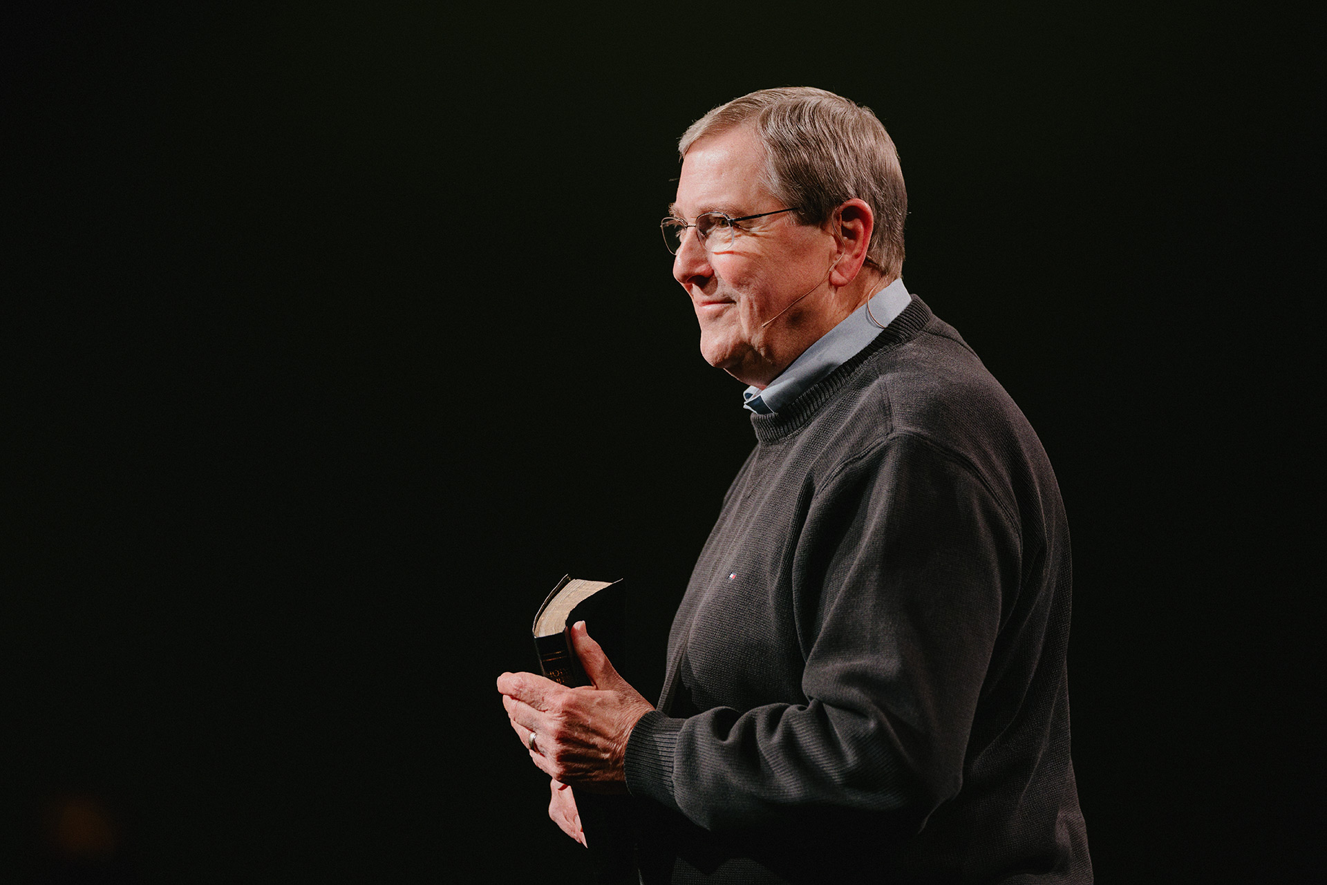 Pastor Emeritus Ken Harrell preaching with Bible in hand
