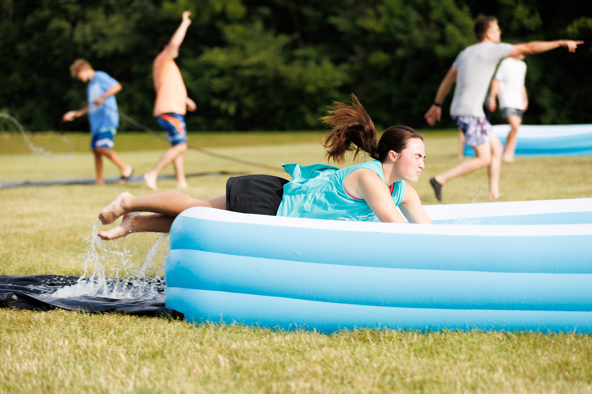teen sliding into a pool