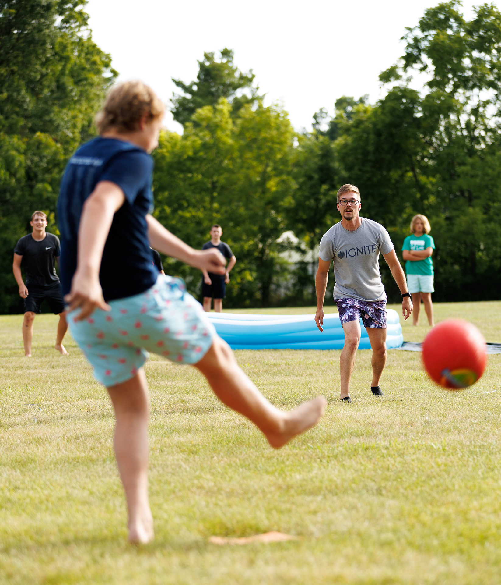 teens playing kickball outside