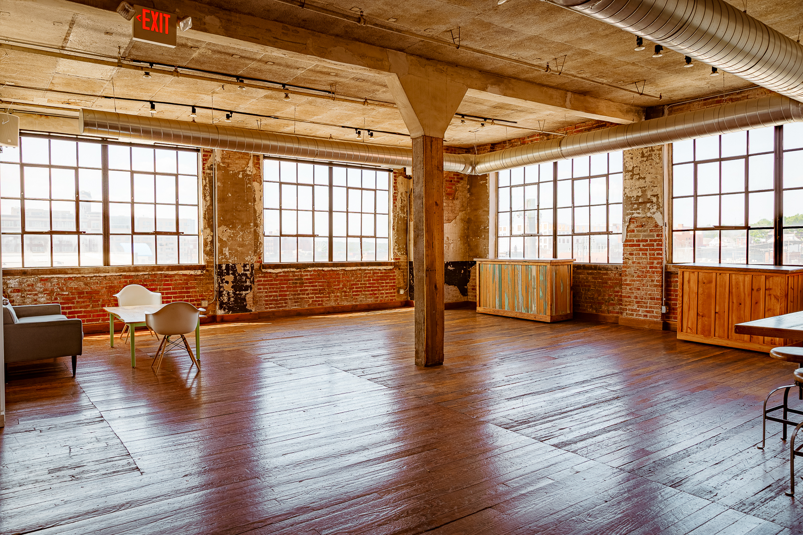 A large room with a wooden floor and a brick wall.