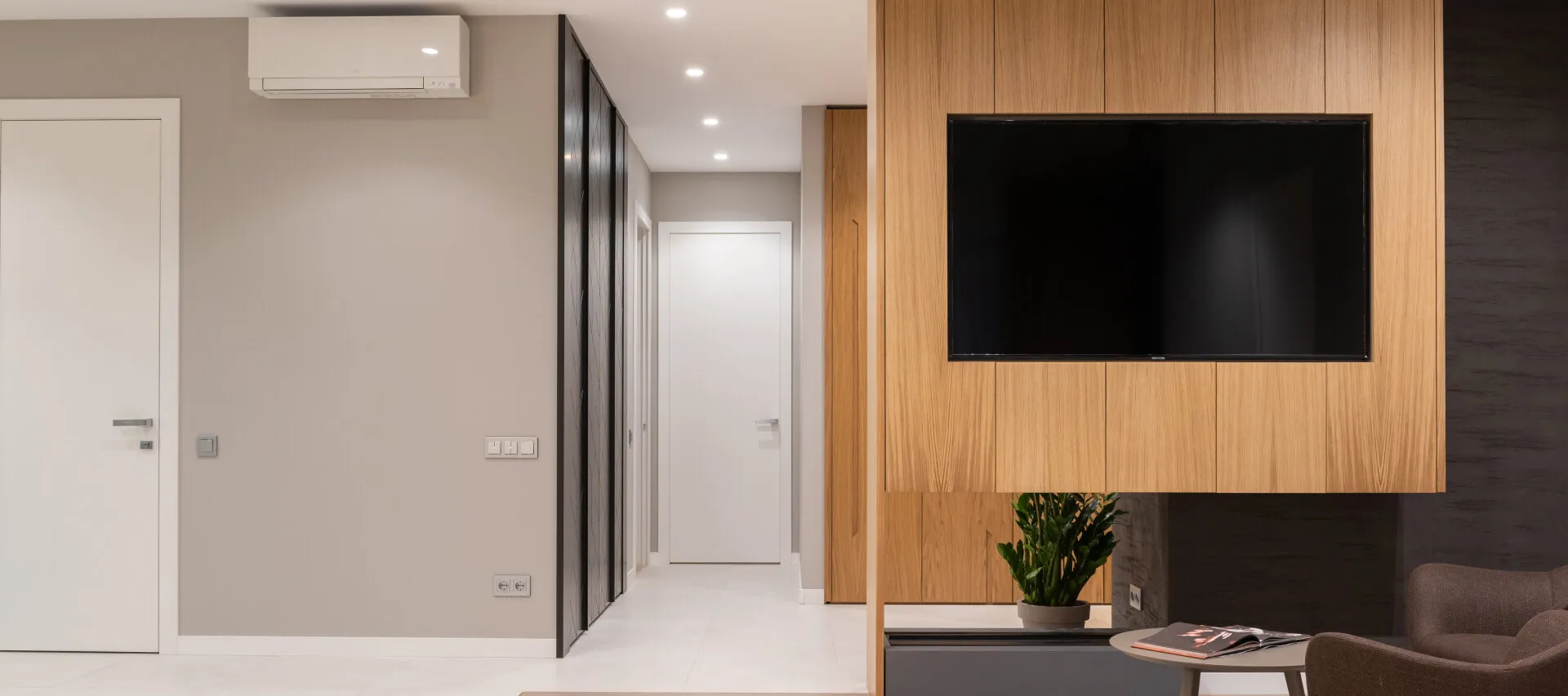 Modern living room with wooden accent wall, TV, and minimalist design