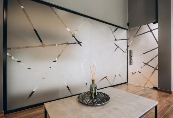 Frosted glass window with geometric lines and reed diffuser on table