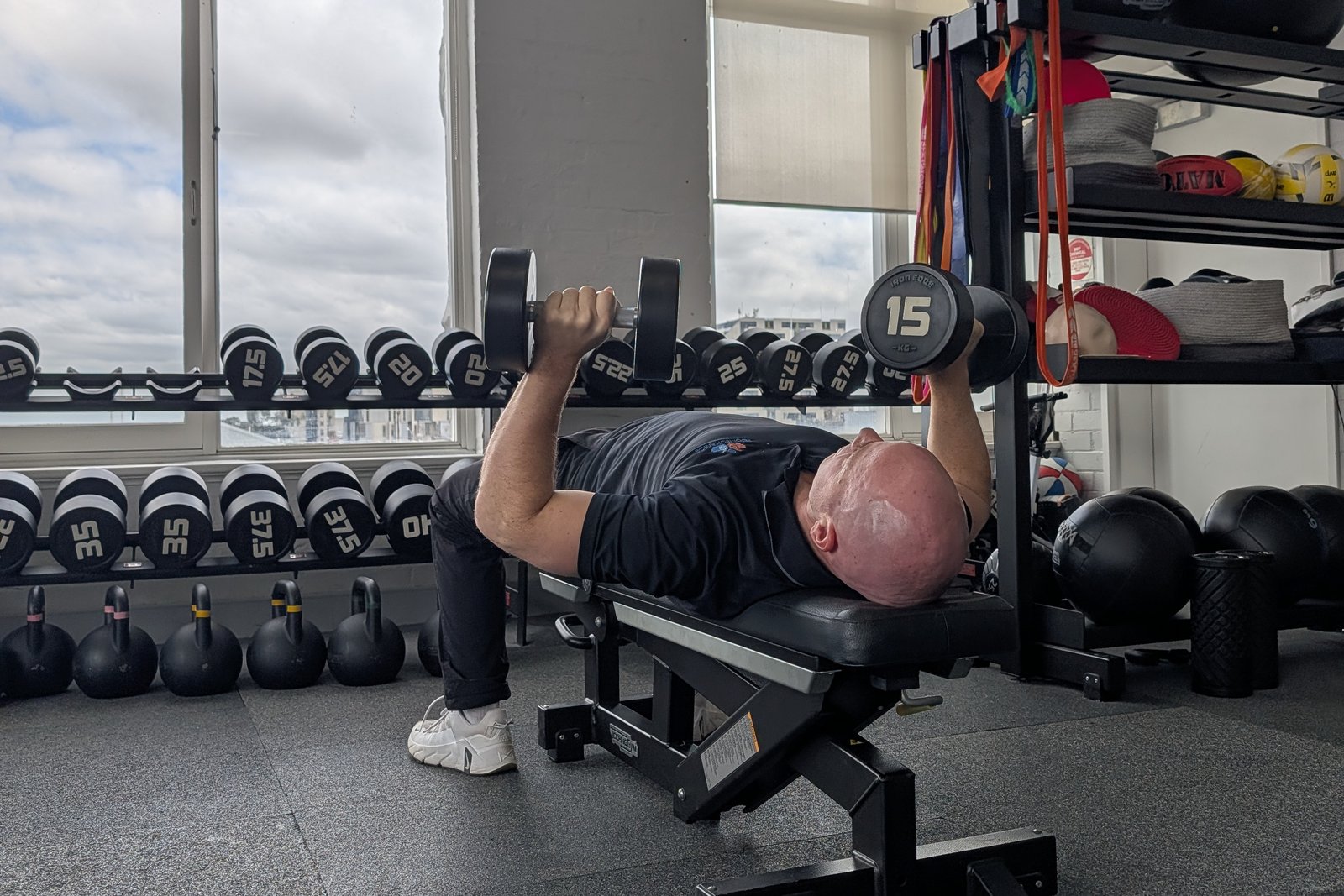 Dumbbell bench press on the gym floor at The Biomechanics, building shoulder strength
