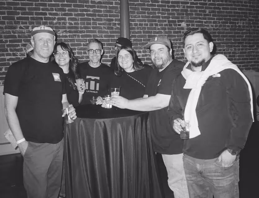A picture of Marissa and co-workers standing around a table.
