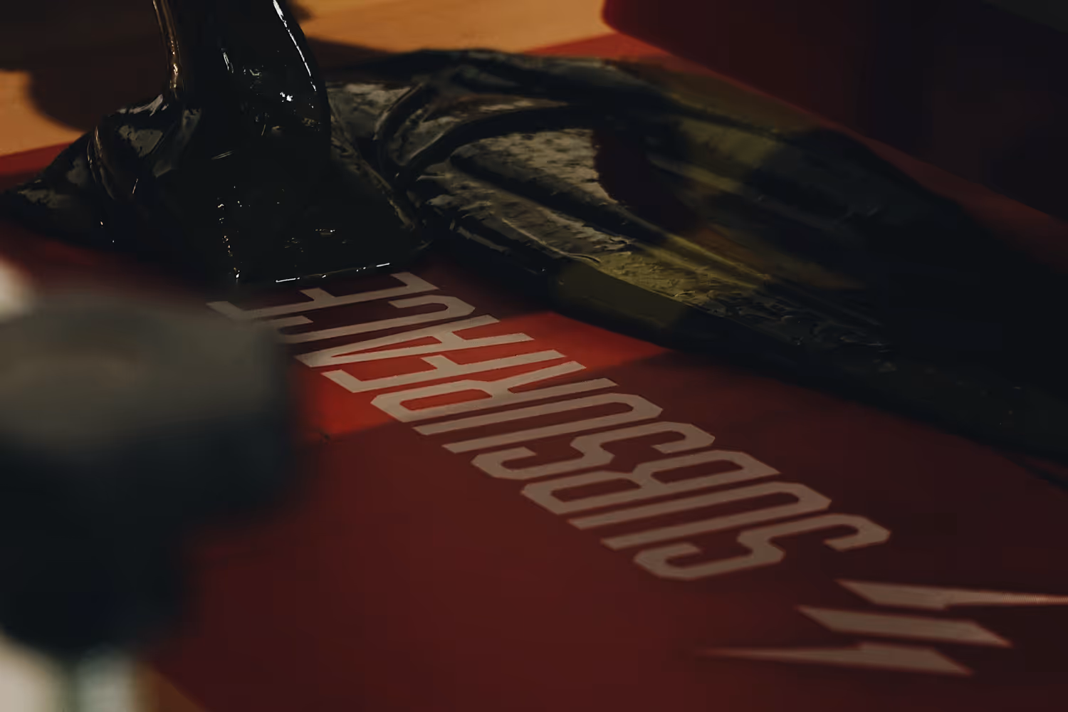 An image of ink being loaded into a screen, part of the screen printing proess.