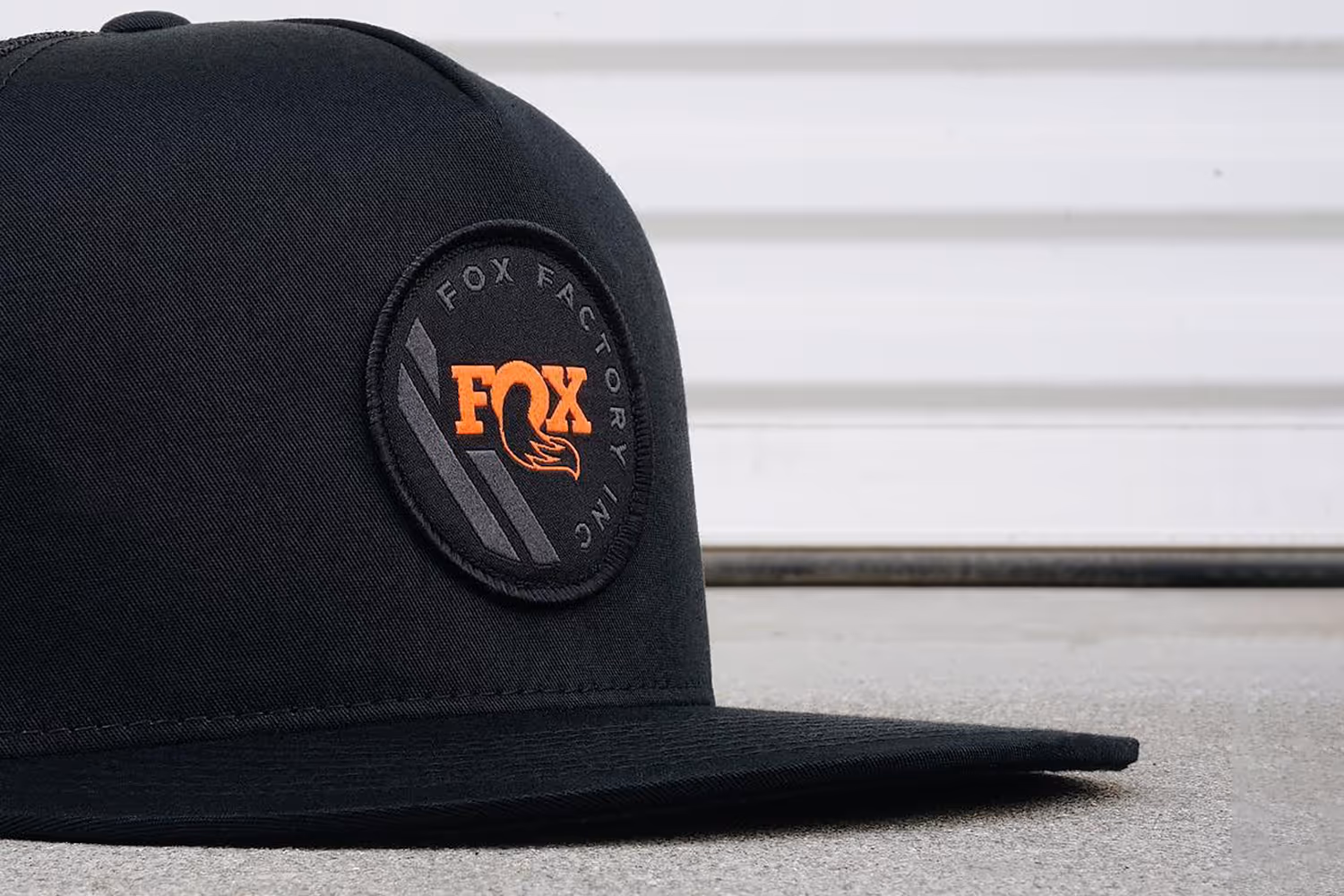 A trucker hat with a woven patch featuring the FOX Factory logo.