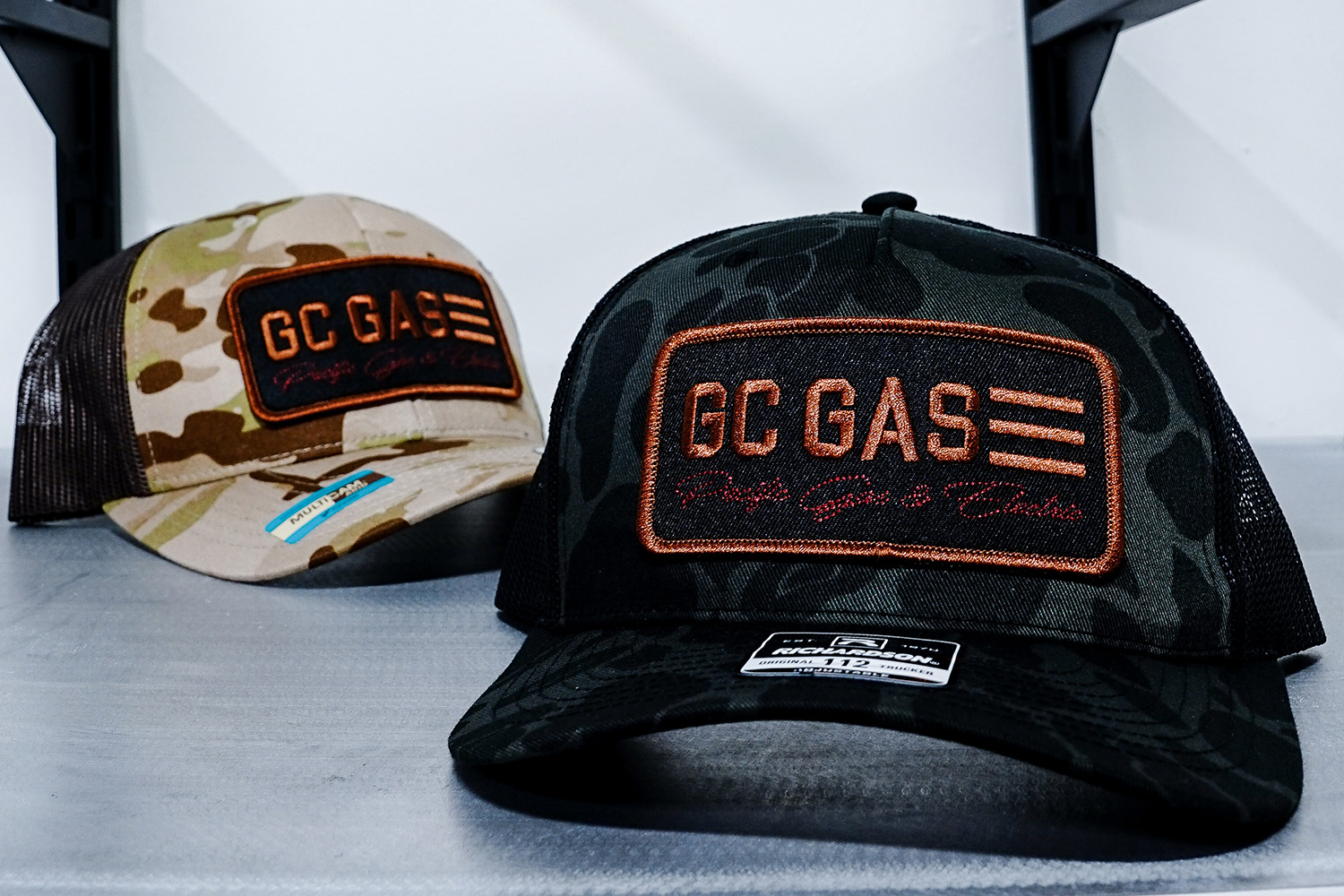 An image of a camo hat with a custom embroidered patch.