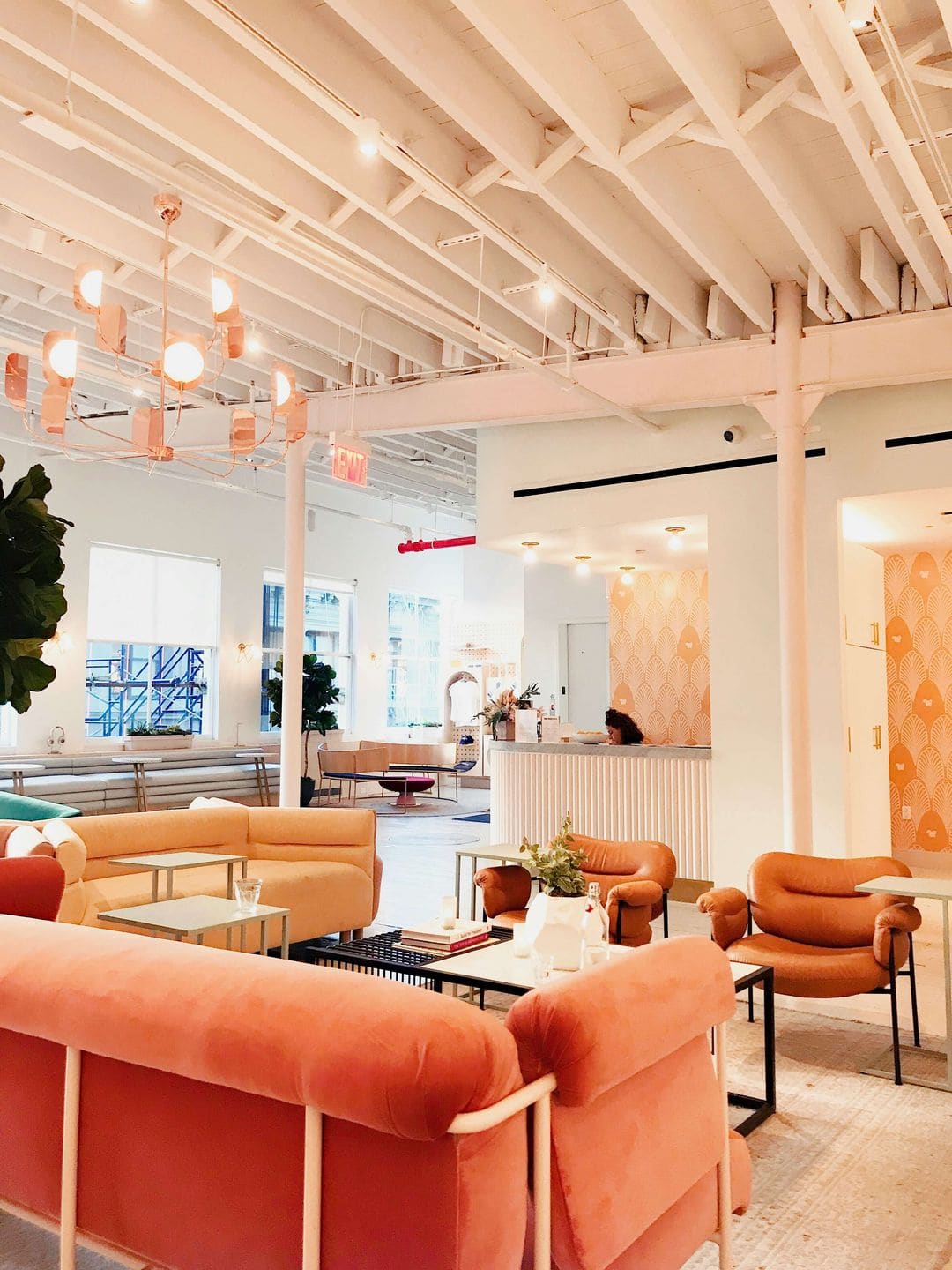 “Vibrant serviced office lounge area featuring pastel seating, open ceilings and warm modern décor designed for collaborative working.