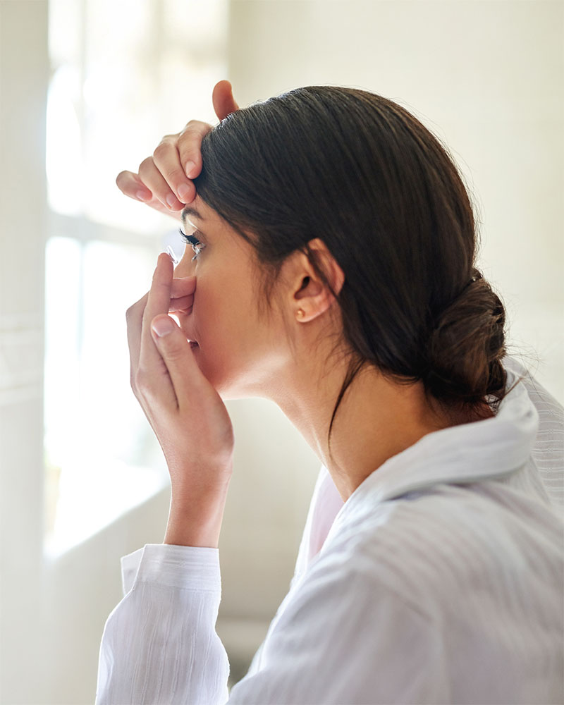 Kvinne tar på kontaktlinser med korrekt hygene etter besøk hos OSLO SYN