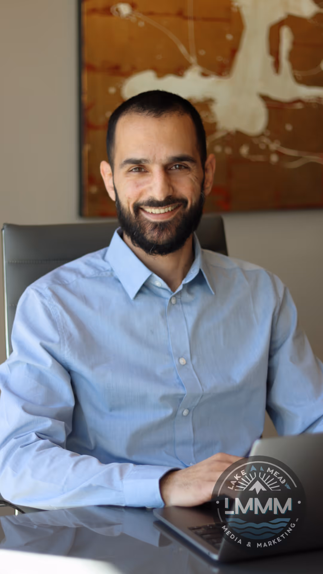 Professional business headshot photography Nevada - executive portrait in office setting with laptop by Lake Mead Media Marketing