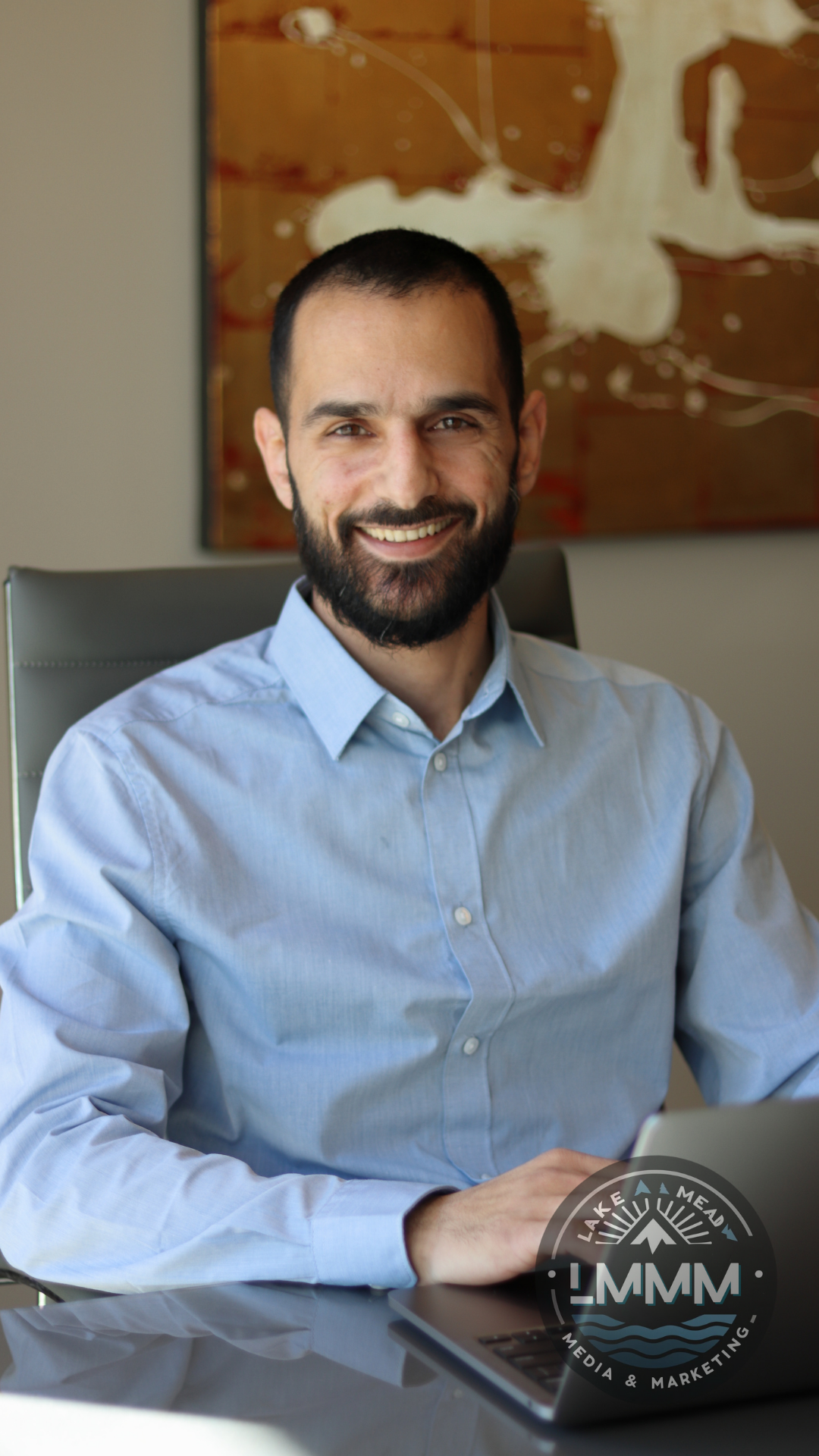 Professional business headshot photography Nevada - executive portrait in office setting with laptop by Lake Mead Media Marketing