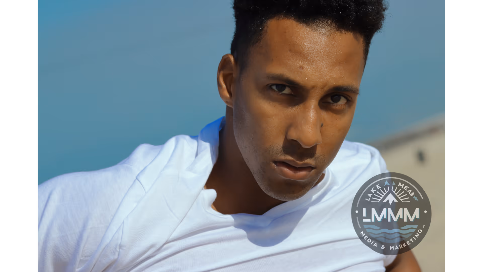 Professional portrait photography Las Vegas - young man in white hoodie against blue background by Lake Mead Media Marketing