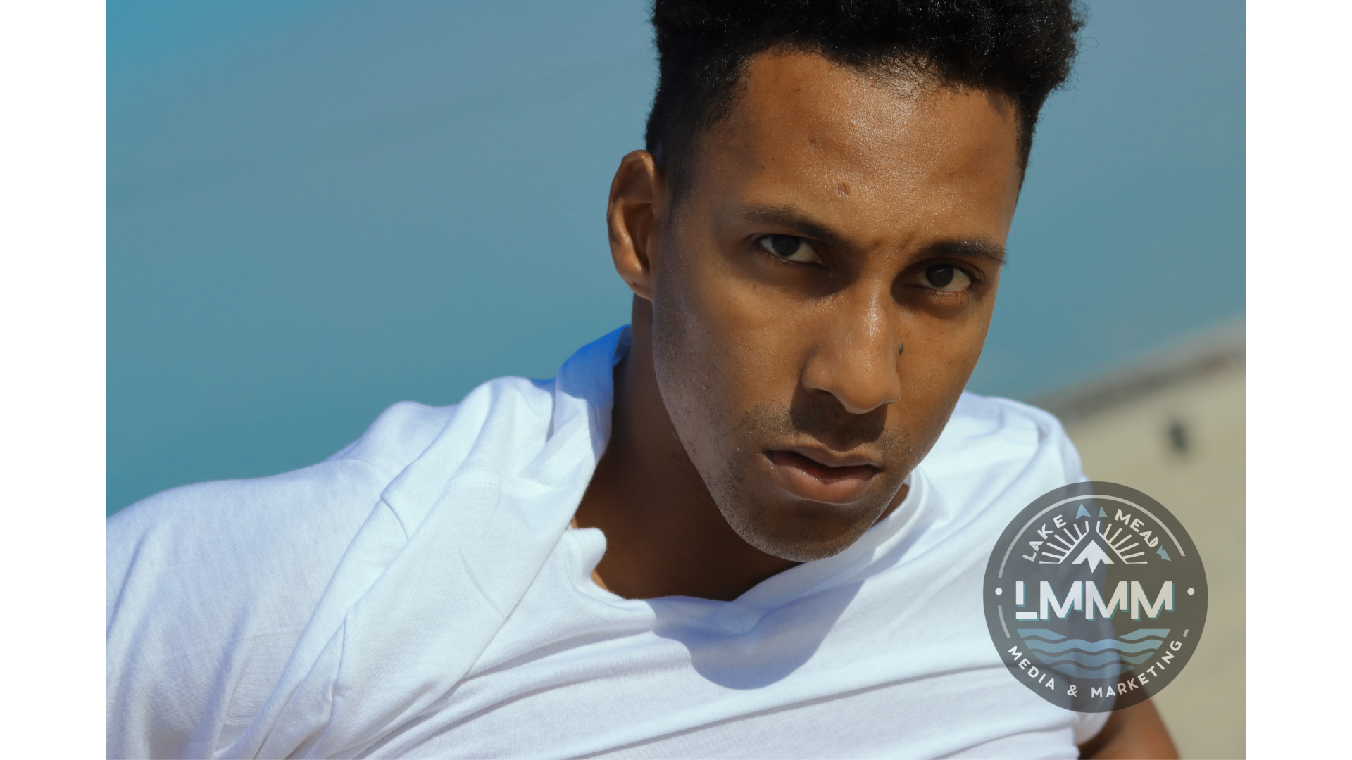Professional portrait photography Las Vegas - young man in white hoodie against blue background by Lake Mead Media Marketing