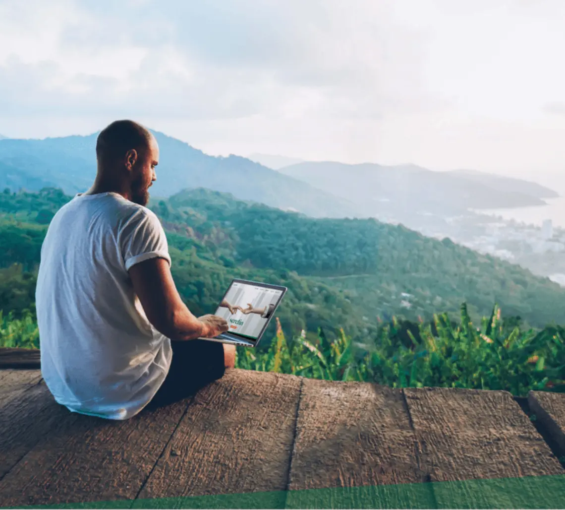 Man on laptop in beautiful scenery