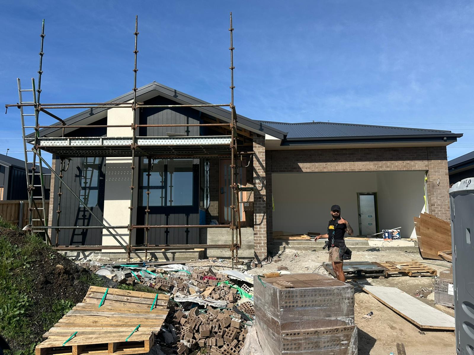 Sorell residence under construction with a front gable and dark vertical cladding
