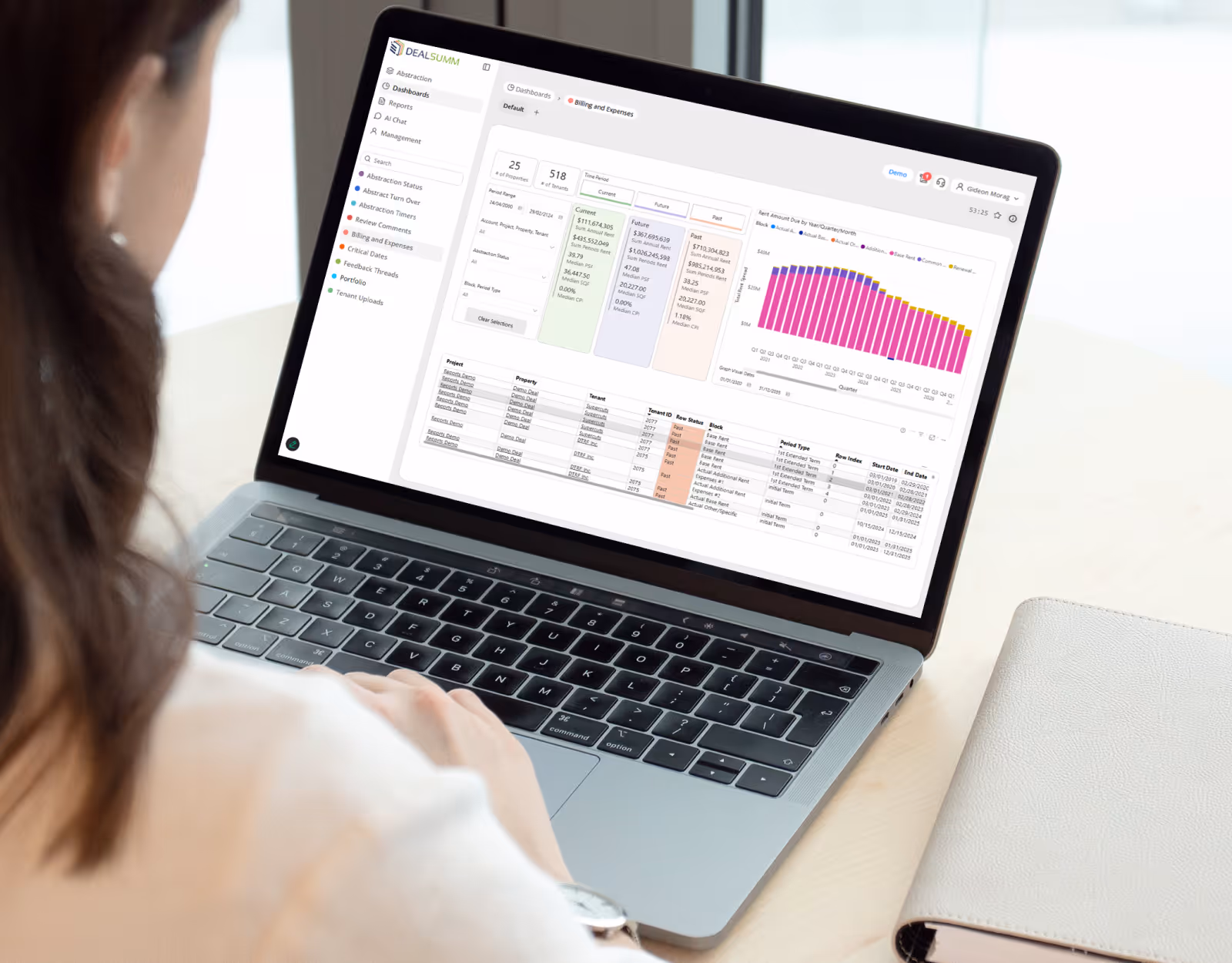 Person using a laptop displaying a Dealsumm dashboard with charts, tables, and reporting options for billing and expenses in DEALSUMM software.
