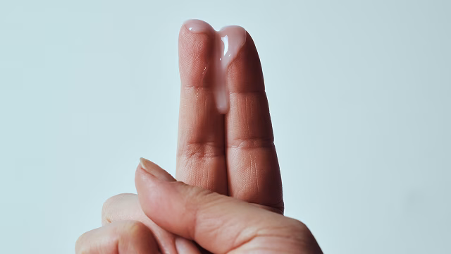 Image of fingers with thin, gray BV discharge on them above a light background