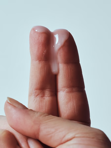 Image of fingers with thin, gray BV discharge on them above a light background
