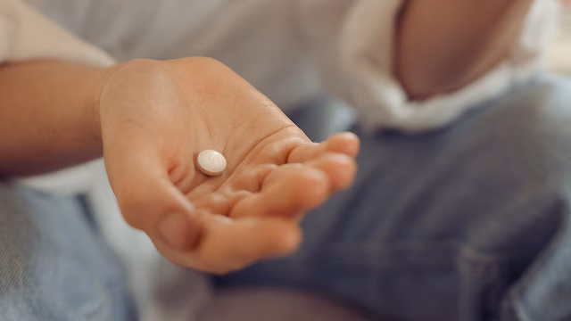Image of hand holding abortion pill mifepristone