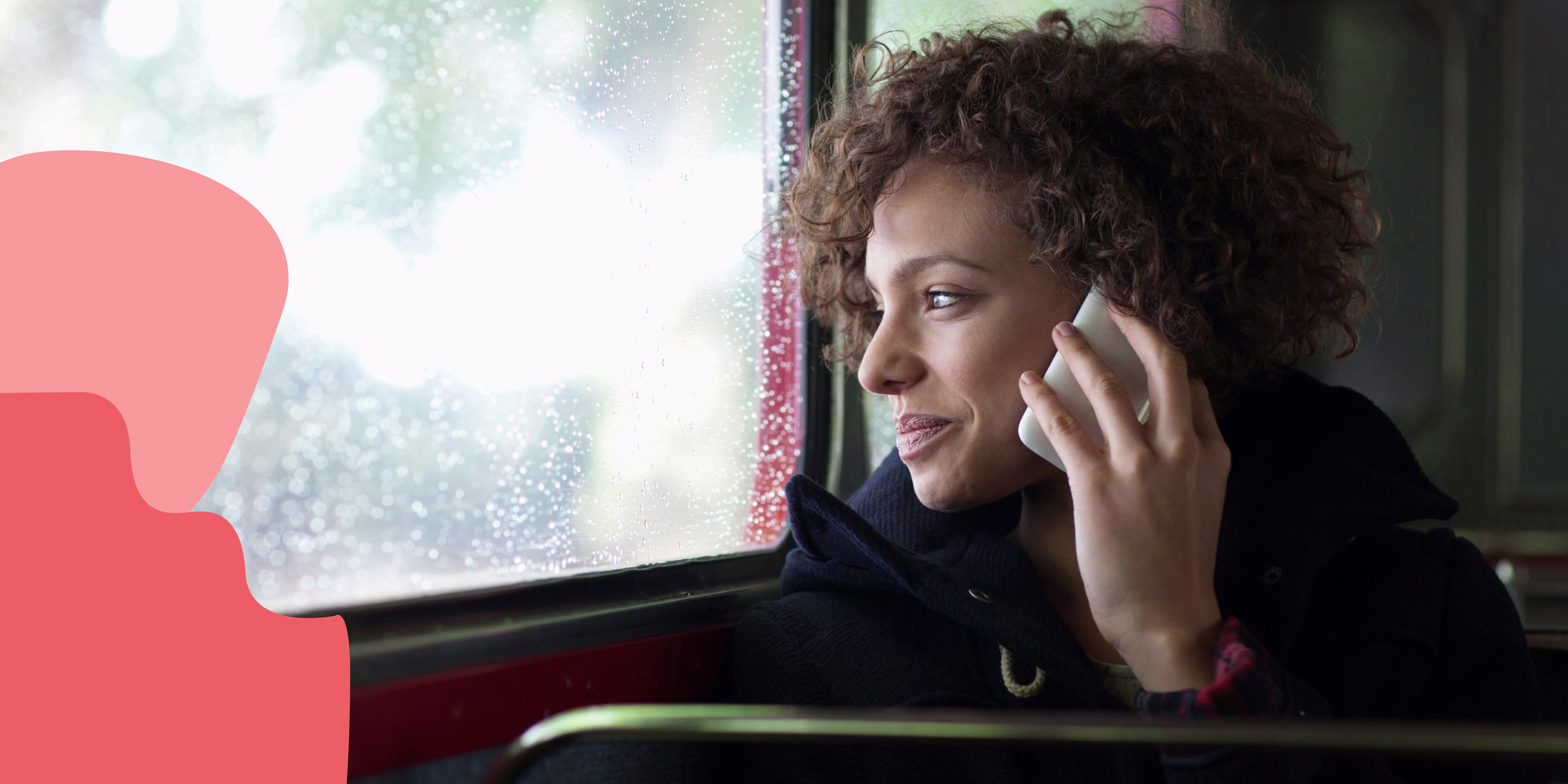 Image of woman on a bus talking on the phone while looking outside