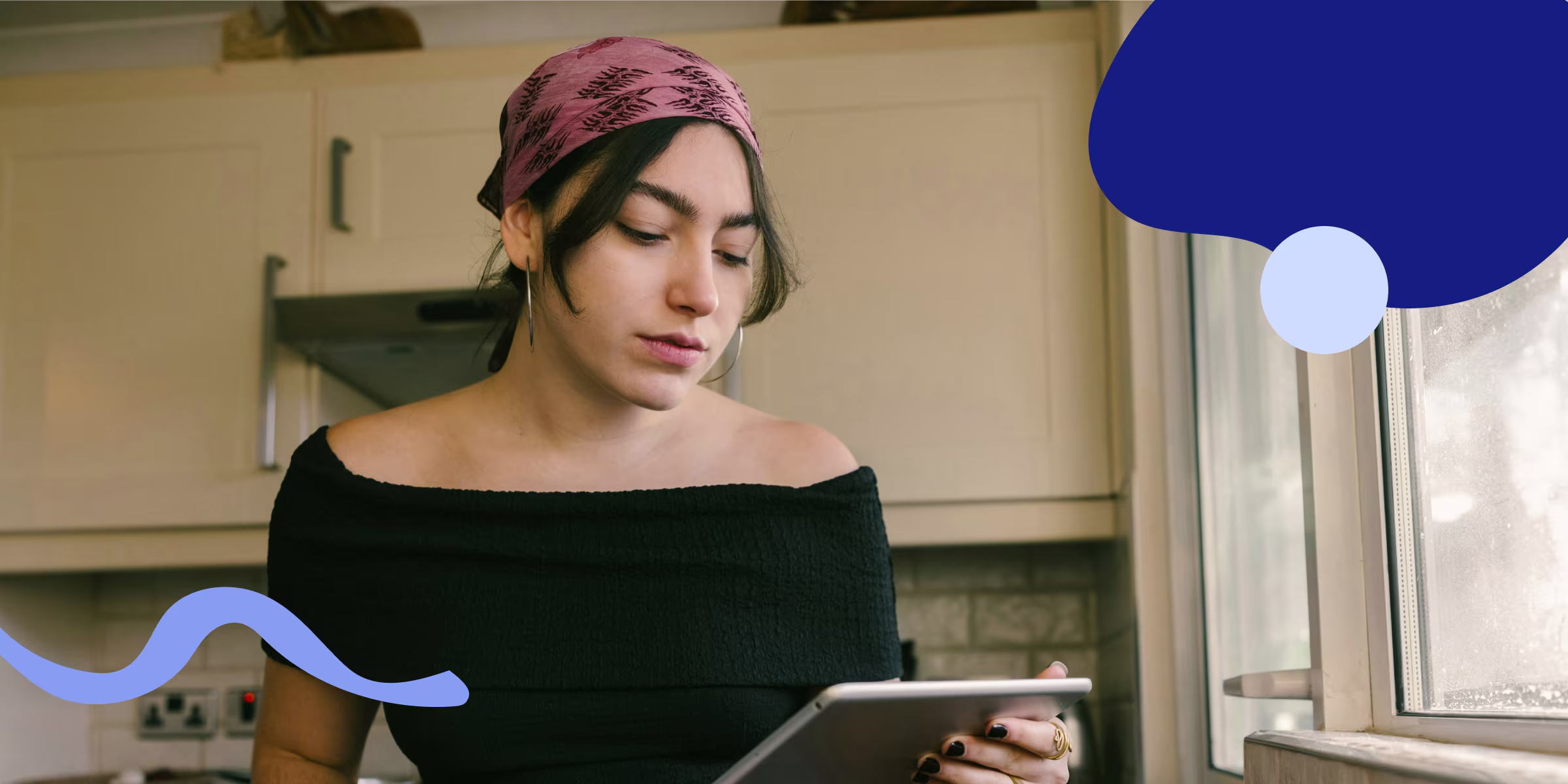 Woman wearing a bandana looking at a tablet researching birth control options online