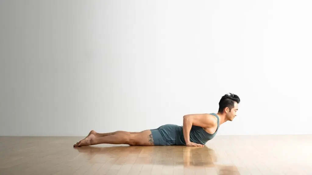 Person performing a prone back extension exercise on the floor