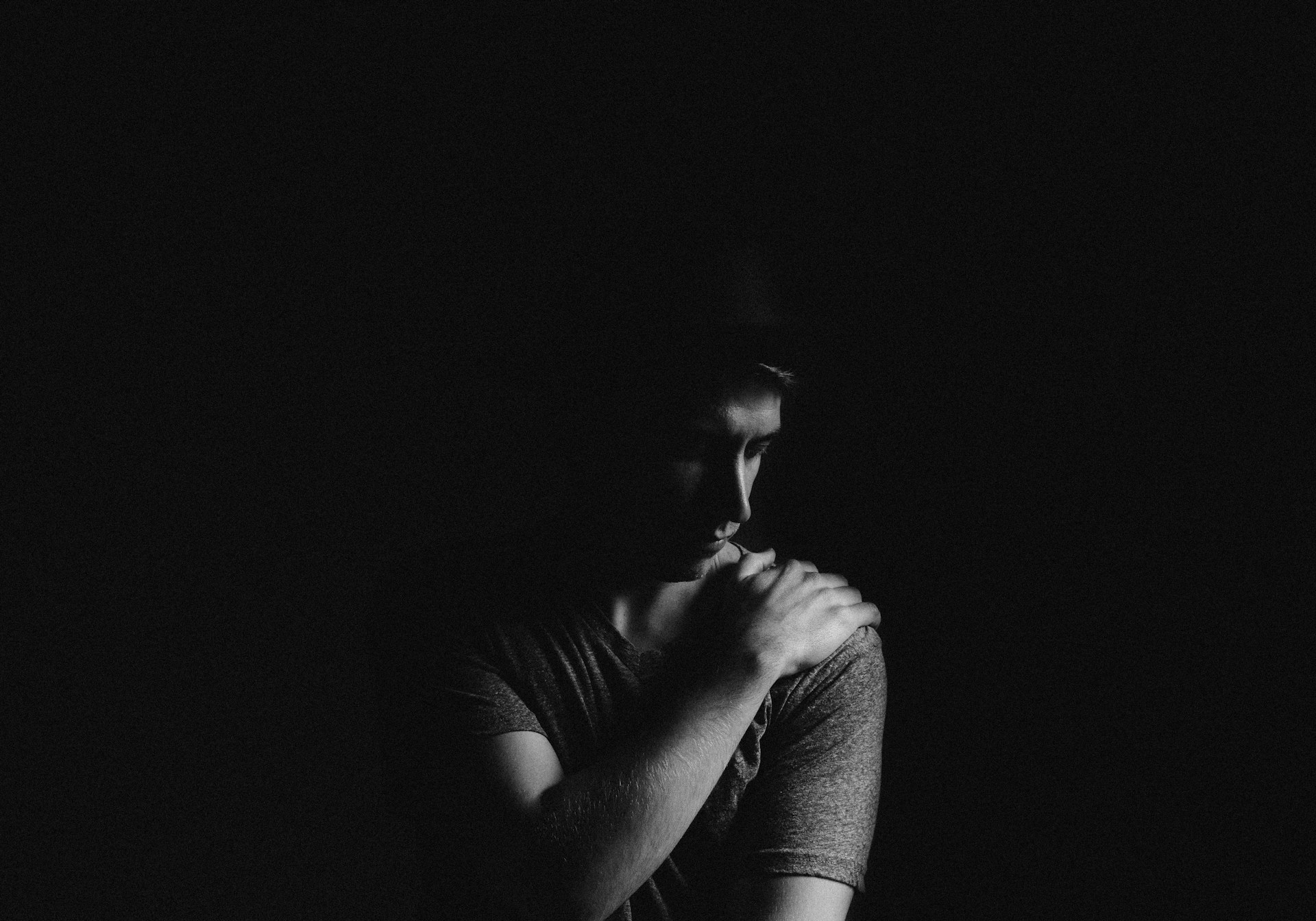 Person holding their shoulder due to shoulder pain