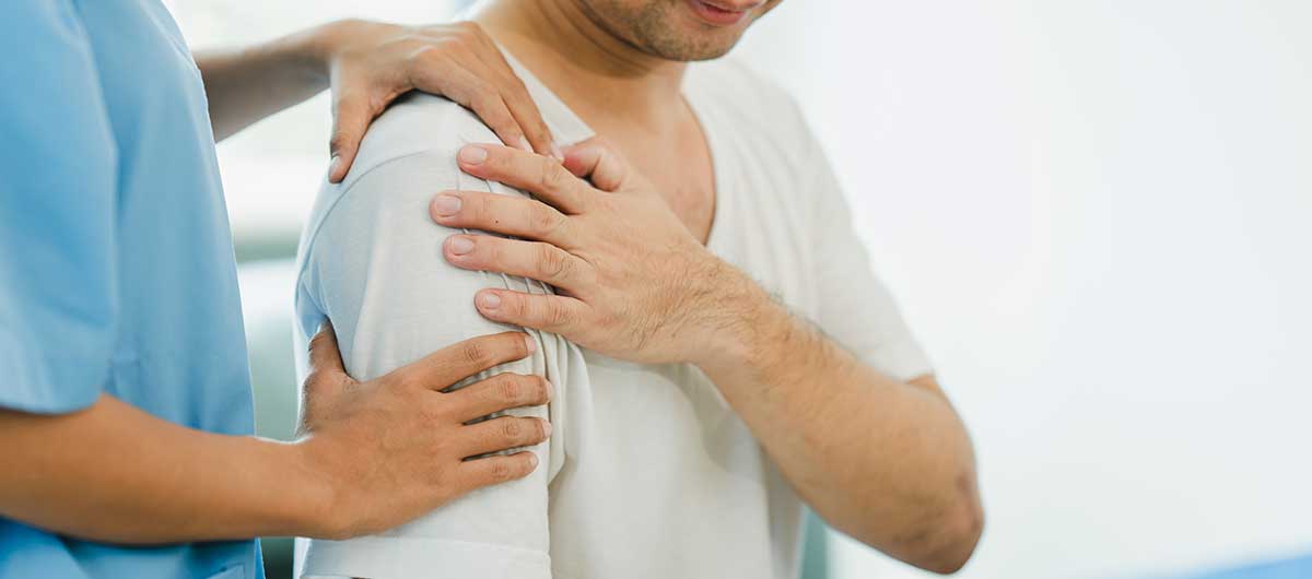 Patient with shoulder pain being examined by a healthcare professional.