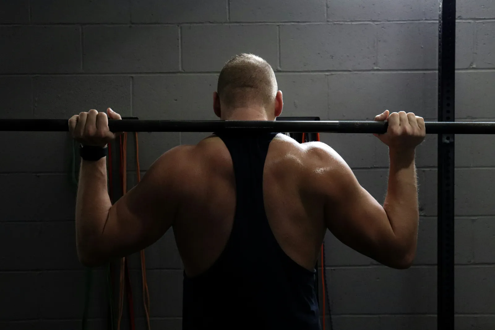 Man performing a barbell shoulder exercise in a gym