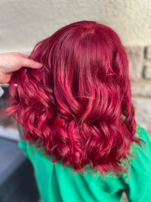 une femme avec les cheveux ondulés et de couleur rouge