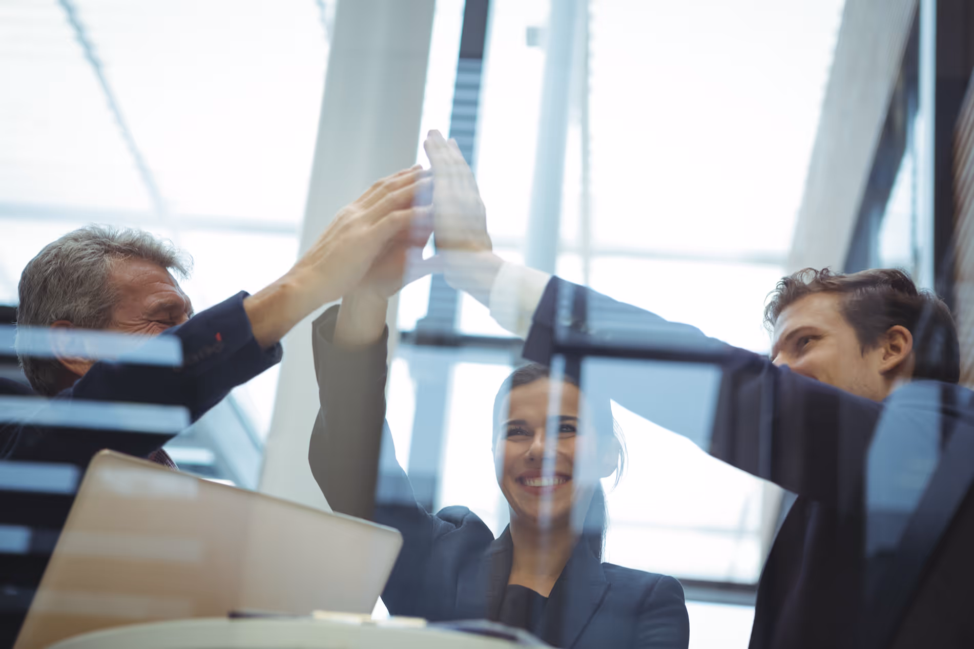 Geschäftsteam feiert Erfolg mit High-Five im Büro