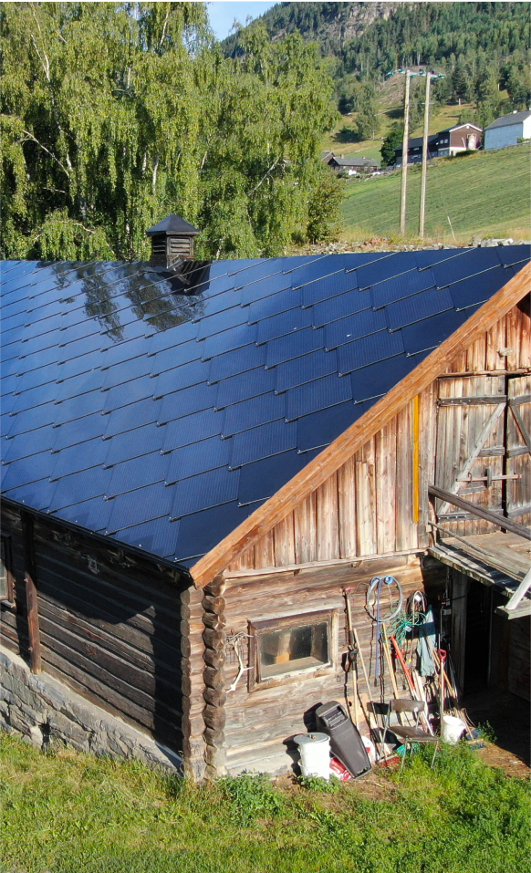 A barn with a metal roof and a blue sky.