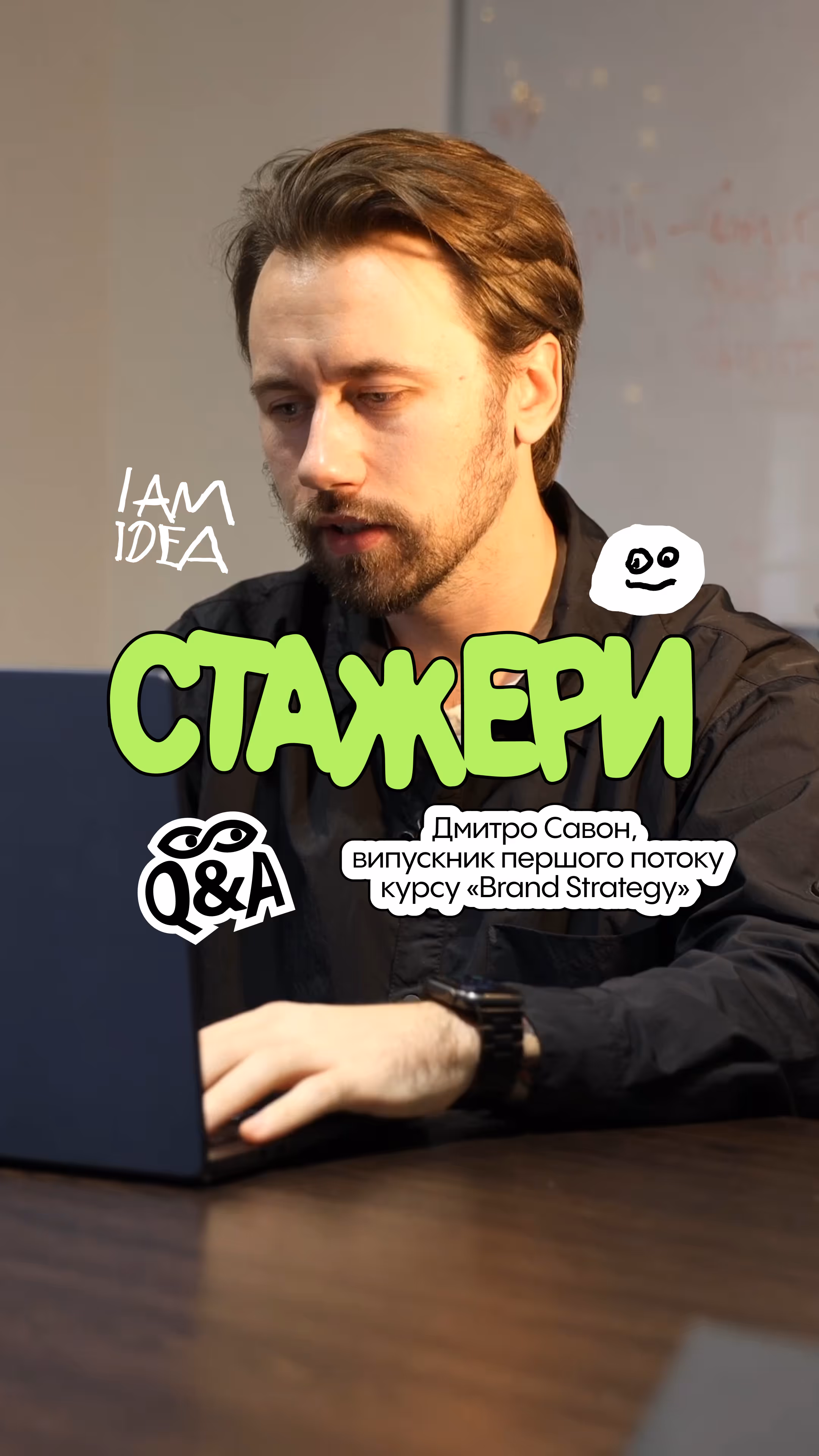 Man with beard and mustache working on a laptop at a wooden table, with graphic text in Ukrainian and English around him.