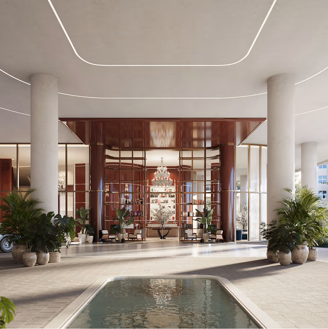 Elegant building entrance with large pillars, potted plants, a water feature in the foreground, and a chandelier visible through glass doors.